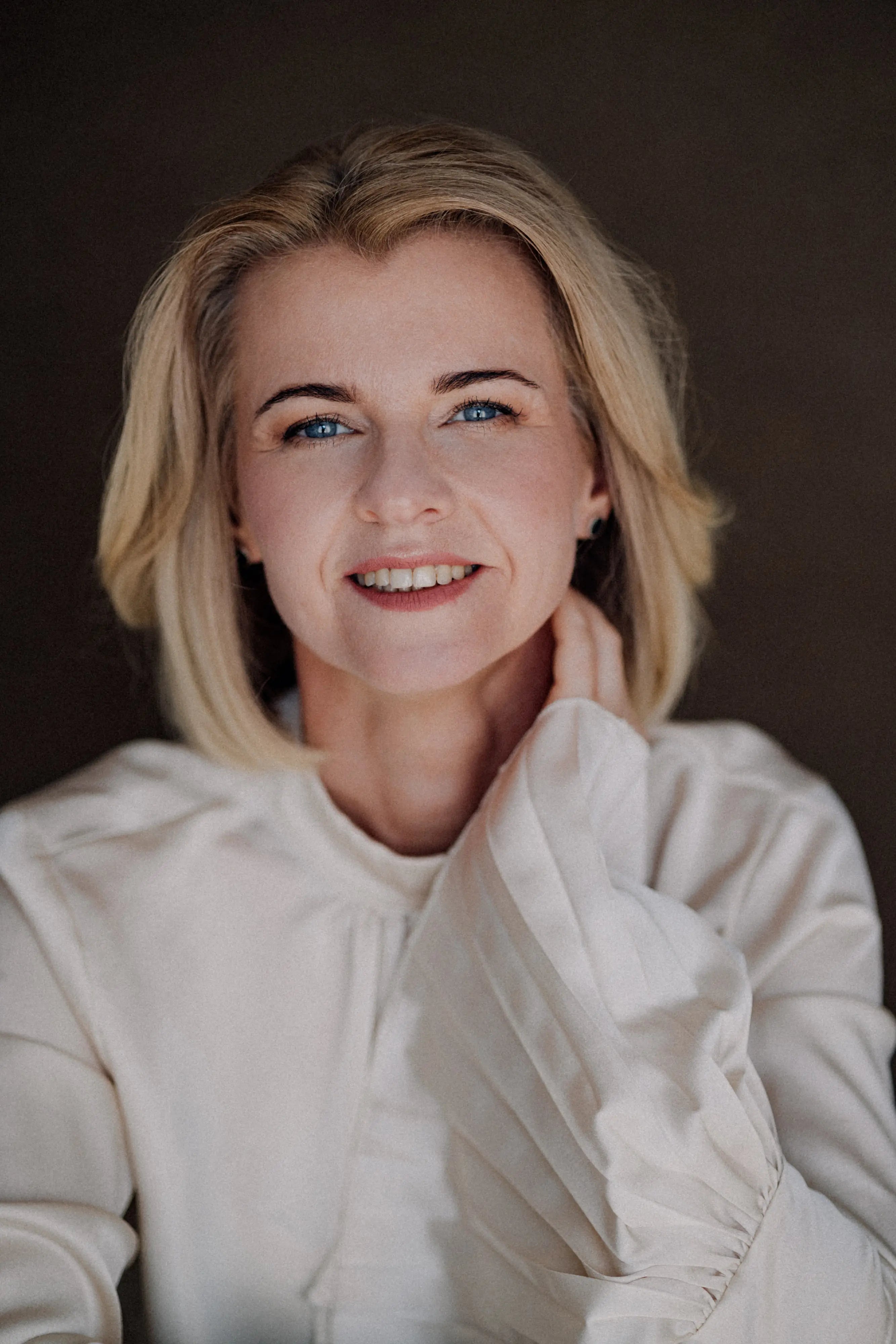 Portret kobiety w jasnej koszuli – profesjonalny wizerunek liderki.