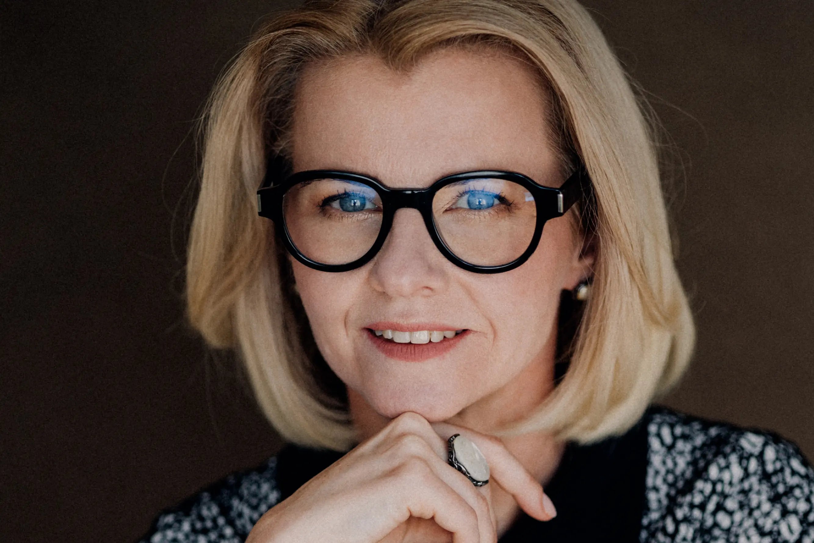 Portret kobiety w okularach – profesjonalny wizerunek ekspertki biznesowej.